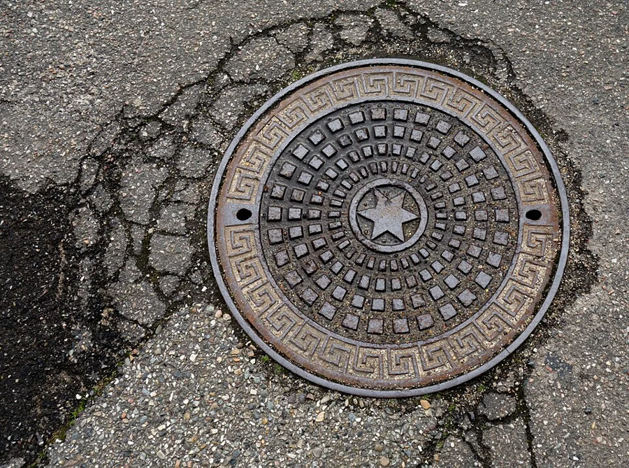 A cast-iron manhole cover set in the road